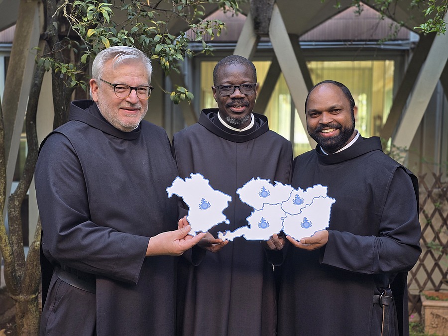 Frater Pascal Ahodegnon (Mitte), Generalprior des Ordens der Barmherzigen Brüder, mit dem bayerischen Provinzial Frater Rudolf Knopp (l.) sowie dem österreichischen Provinzial Frater Saji Mullankuzhy (r.) mit einer symbolischen Landkarte der künftige