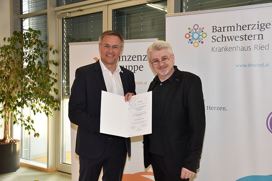Der Ärztliche Direktor des Krankenhauses der Barmherzigen Schwestern Ried, Johannes Huber, übergibt den Preis an Primarius Robert Hörantner.